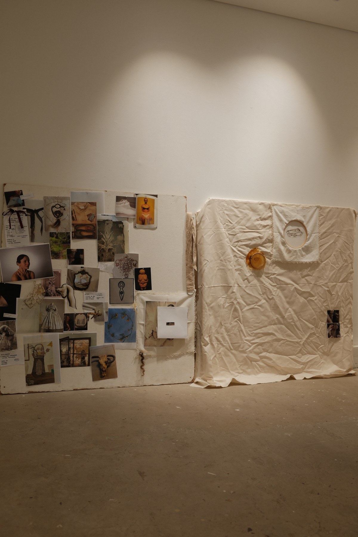 Jasmine Lane's studio — research collage board on the left, a draped white fabric piece with embroidery on the right