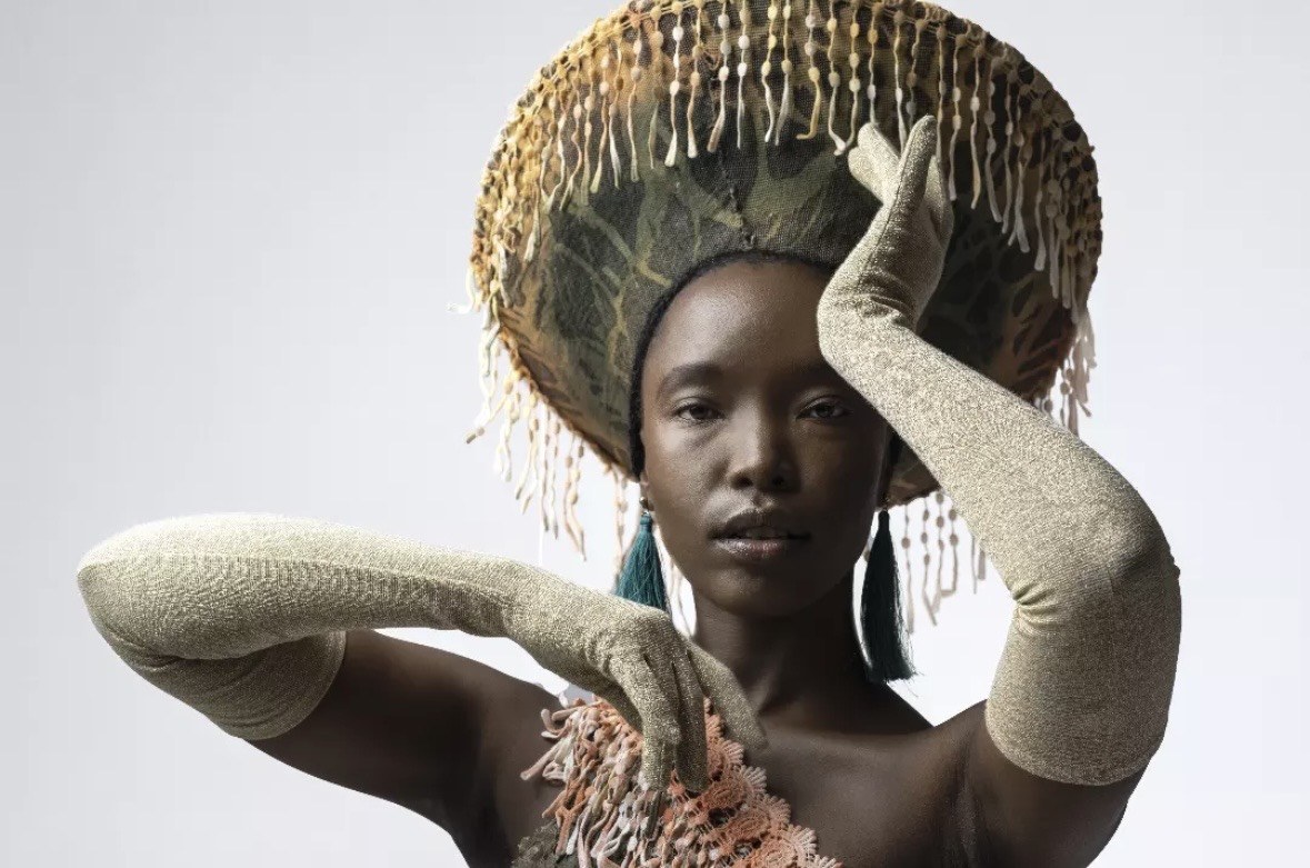 Designed by Kgosi Gift — close detail of the beaded fringed headdress and long knit gloves framing the face