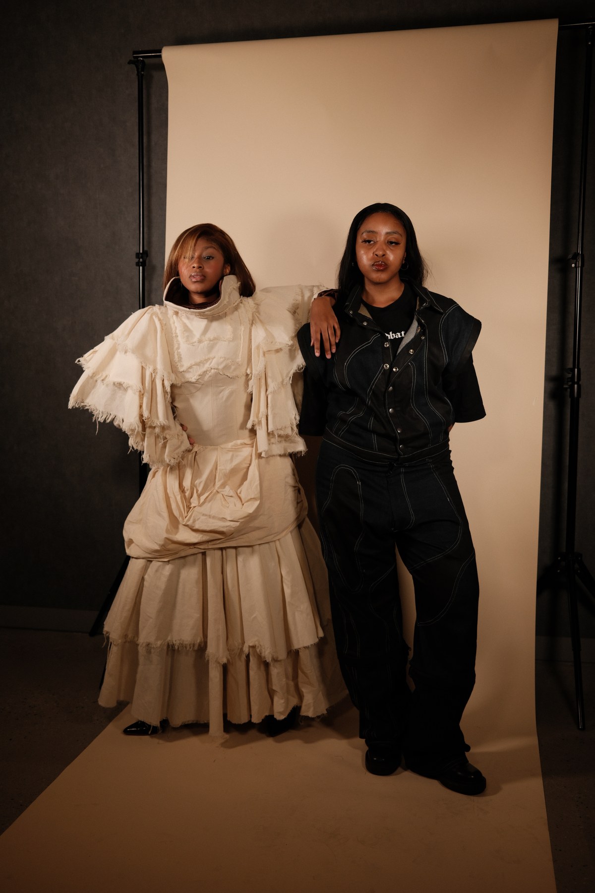 Designed by Mihlali Madikane — a cream tiered gown worn beside Mihlali herself in a contrast-stitched black denim look