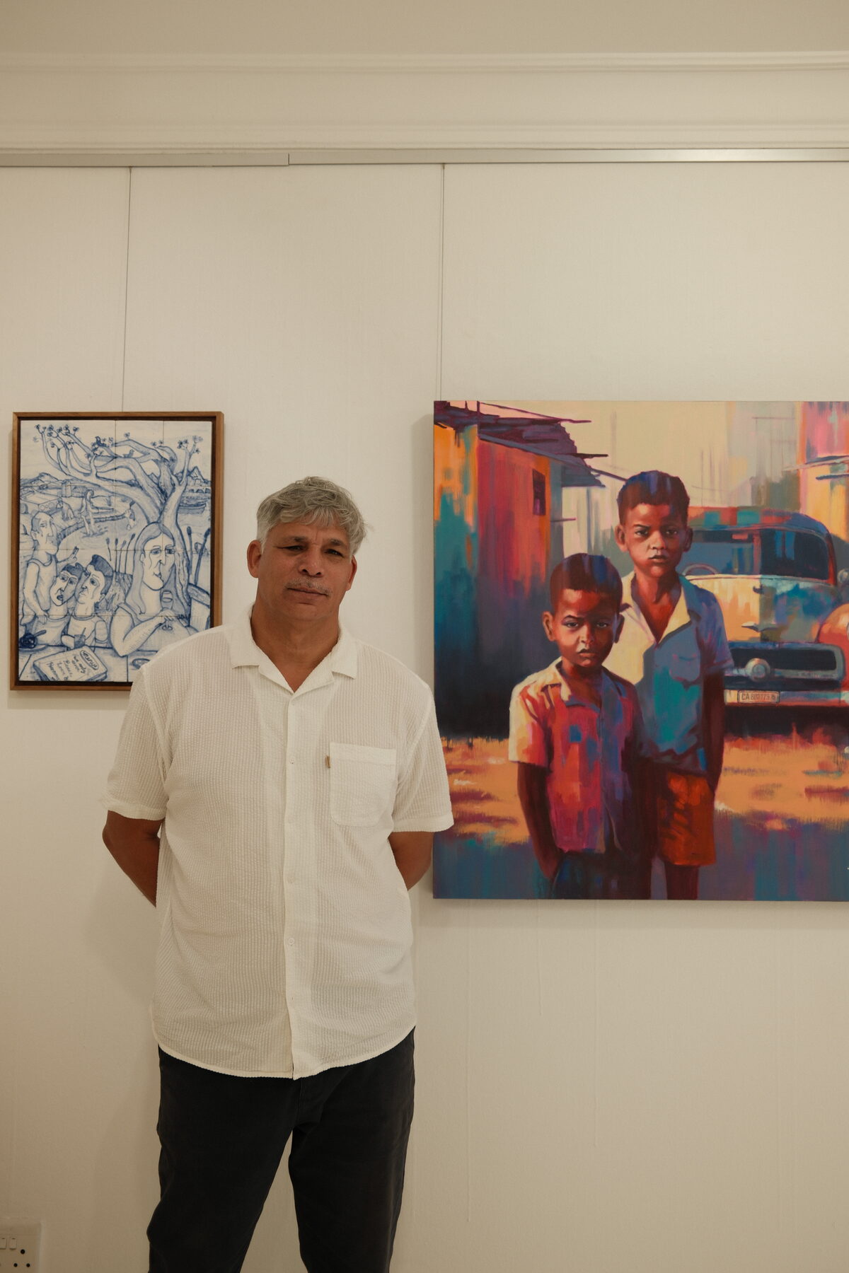 Shaunez Benting standing alongside his work in the gallery